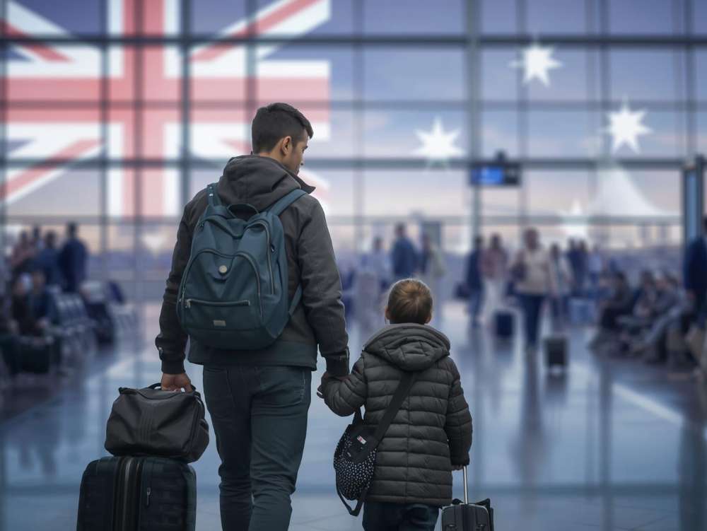 A child holding a hand of his parent. They are moving to Australia.